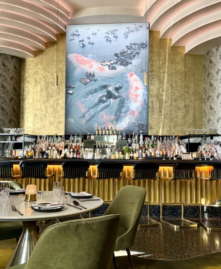 Interior of Animae restaurant in San Diego showing the gold-accented bar, koi artwork, and Art Deco dining room