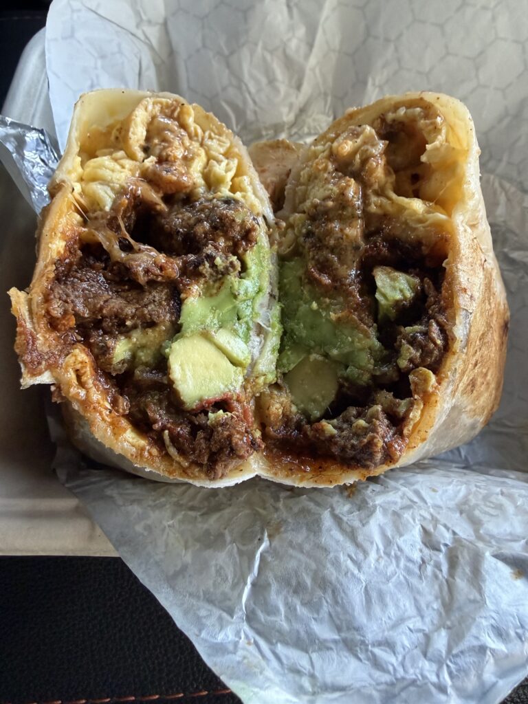 The Cali breakfast burrito cut in half showing steak, egg, and avocado
