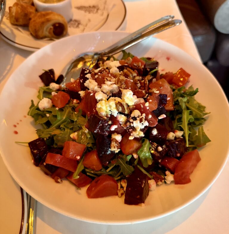 Beet salad with arugula, tomato, and crumbled cheese